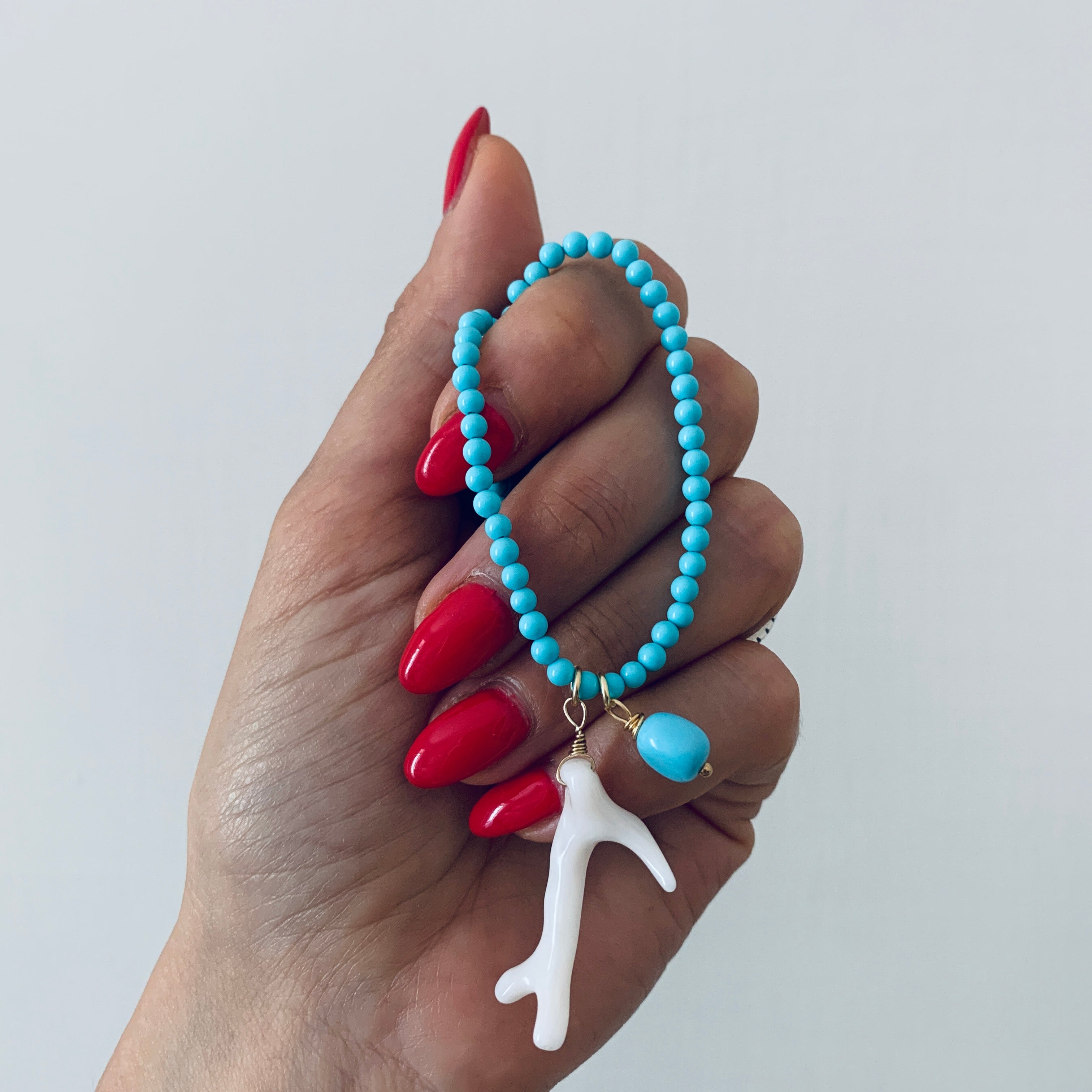 RabiosaJewels. Collana Borea Turchese con perline in pasta di turchese e due ciondoli: un ramo di corallo bianco naturale e una pepita di turchese. argento 925 bagnato oro giallo.