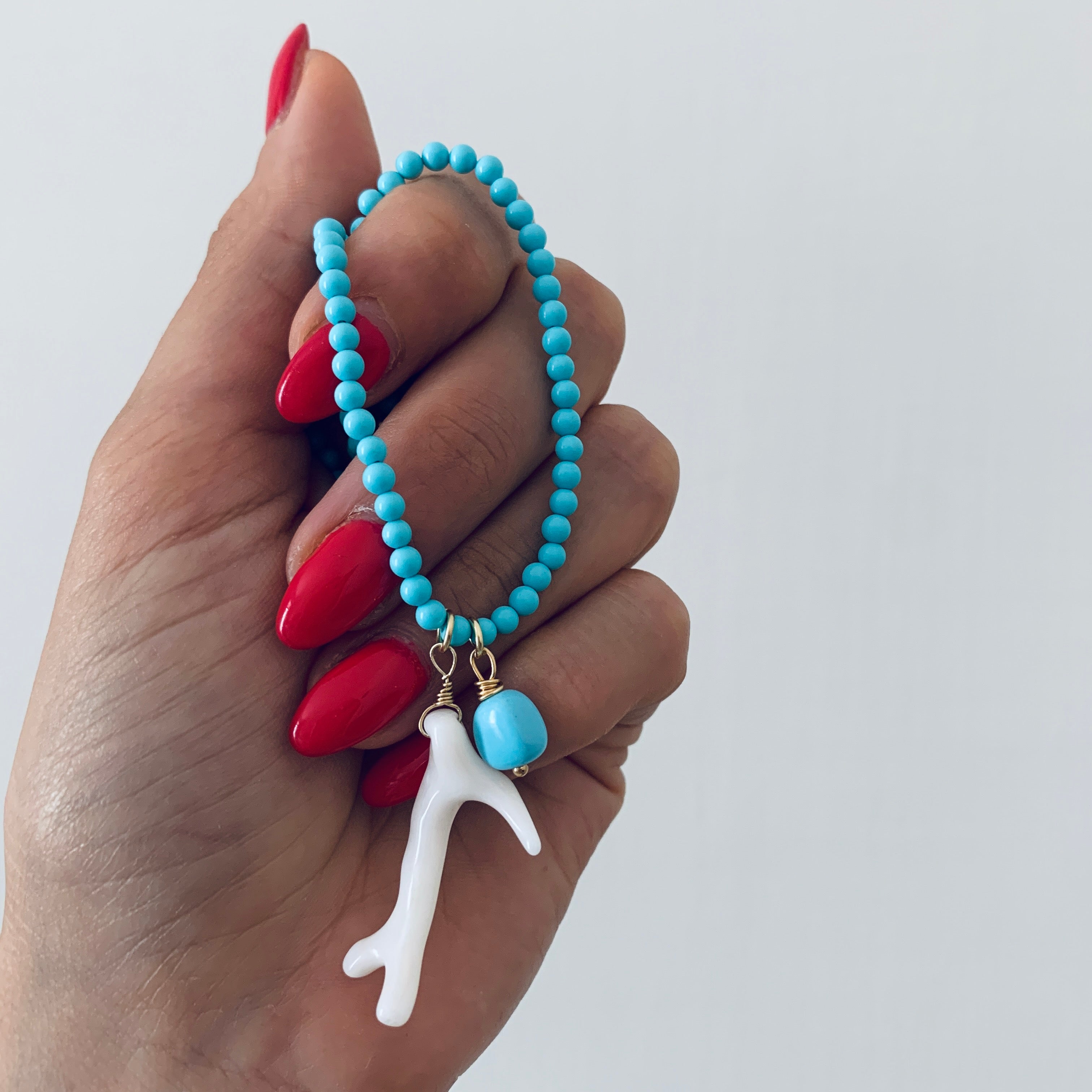 RabiosaJewels. Collana Borea Turchese con perline in pasta di turchese e due ciondoli: un ramo di corallo bianco naturale e una pepita di turchese. argento 925 bagnato oro giallo.