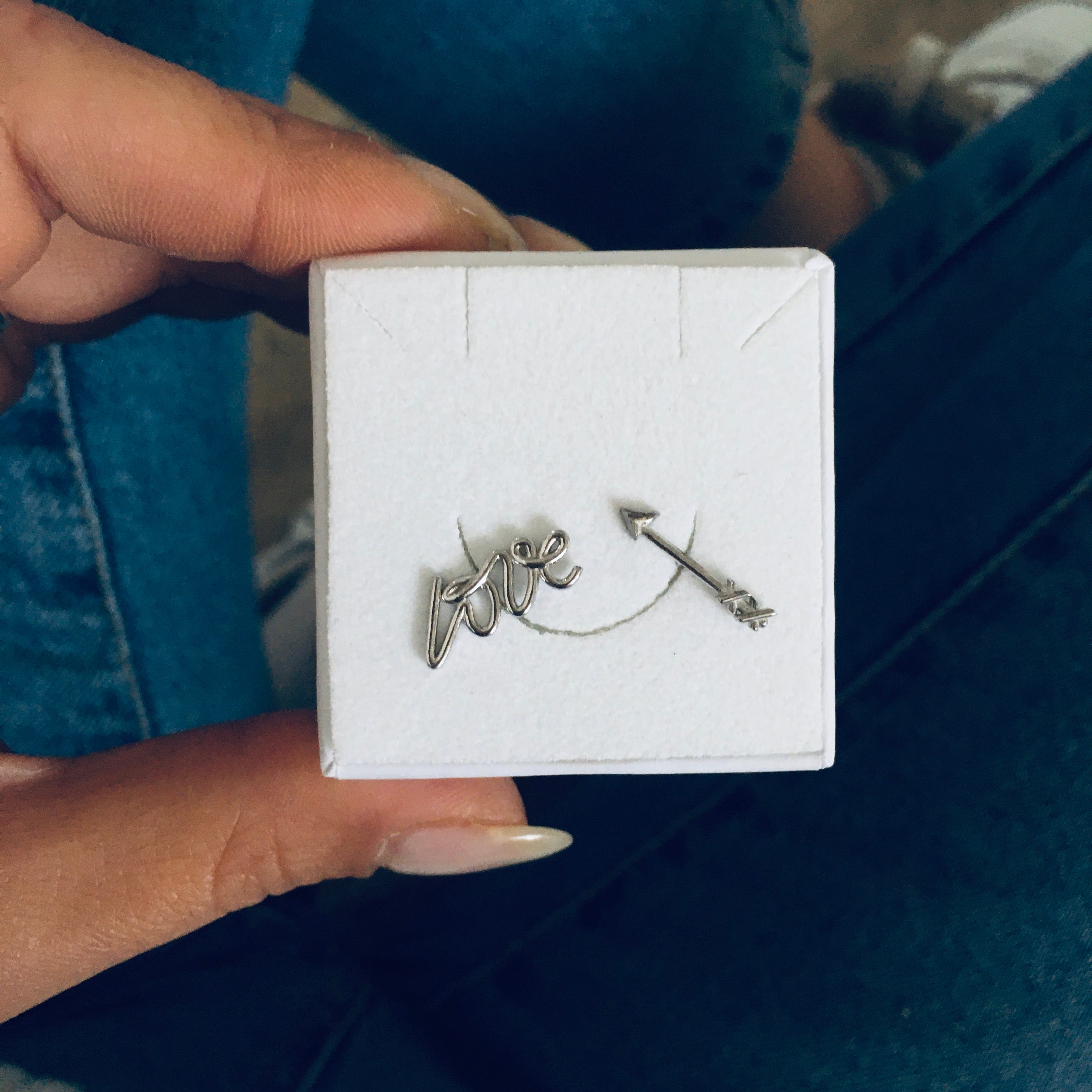 coppia di orecchini da lobo composti dalla scritta love e da una freccia. argento 925