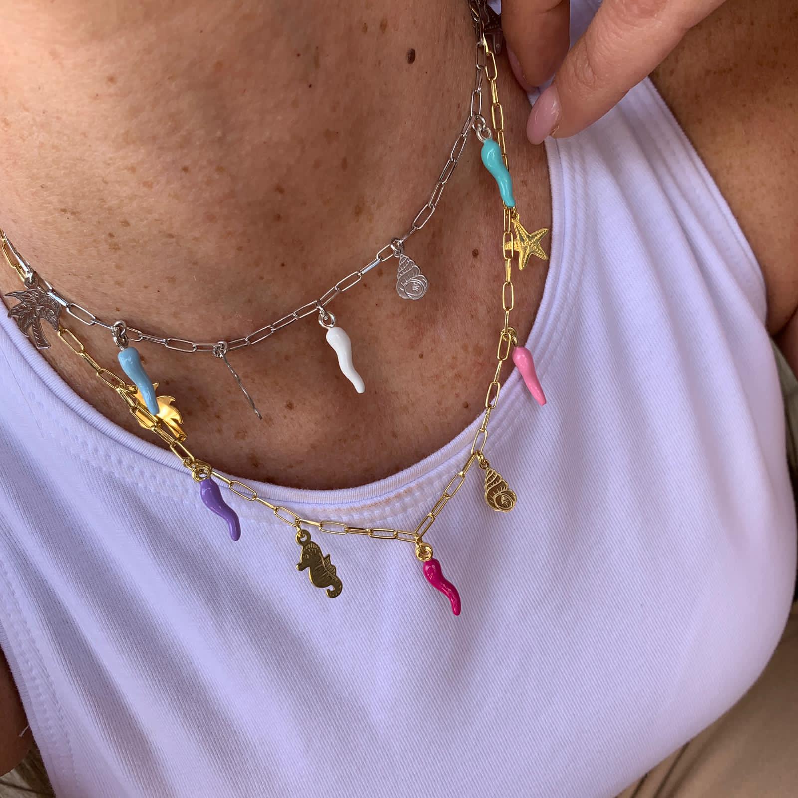 rabiosajewels. collana marina. collana in argento 925 gold con ciondoli marini e cornetti colorati nelle tonalità pastello del rosa e del turchese. ciondolo cavalluccio marino. ciondolo palma. ciondolo conchiglia. ciondolo stella marina. cornetti portafortuna colorati