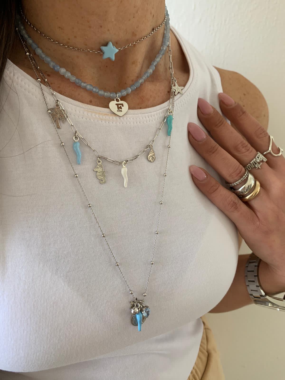 rabiosajewels. collana marina. collana in argento 925 gold con ciondoli marini e cornetti colorati nelle tonalità pastello del rosa e del turchese. ciondolo cavalluccio marino. ciondolo palma. ciondolo conchiglia. ciondolo stella marina. cornetti portafortuna colorati. mix di collane rabiosajewels